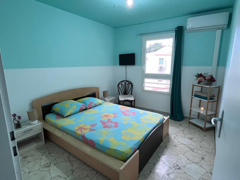 萨莱比梅Chambre d'hôte à 5Mn de l’aéroport的一间卧室配有一张蓝色墙壁的床和一扇窗户