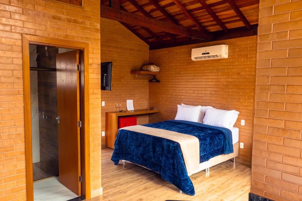 卡皮托利乌Chalés Estância Campestre的卧室配有砖墙内的床铺
