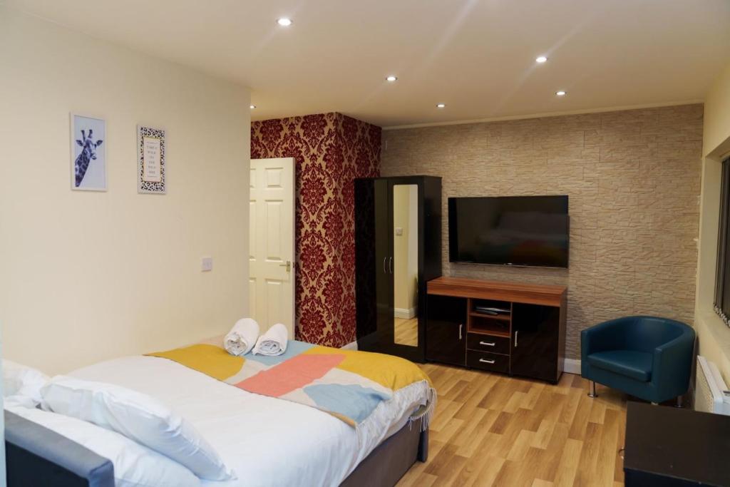 利兹Roundhay Apartments的一间卧室配有一张床和一台平面电视