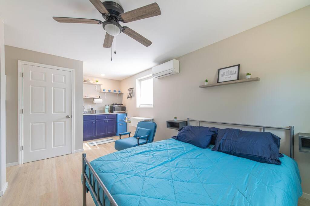 康科德TheCozyCorner in Concord的一间卧室配有蓝色的床和吊扇