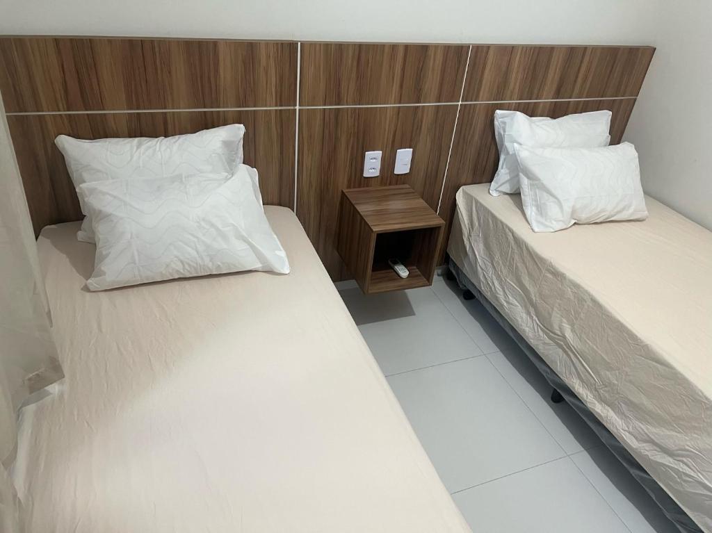 巴雷里尼亚斯Apartamento nos Lencois Confort的一间设有两张床和床头柜的房间
