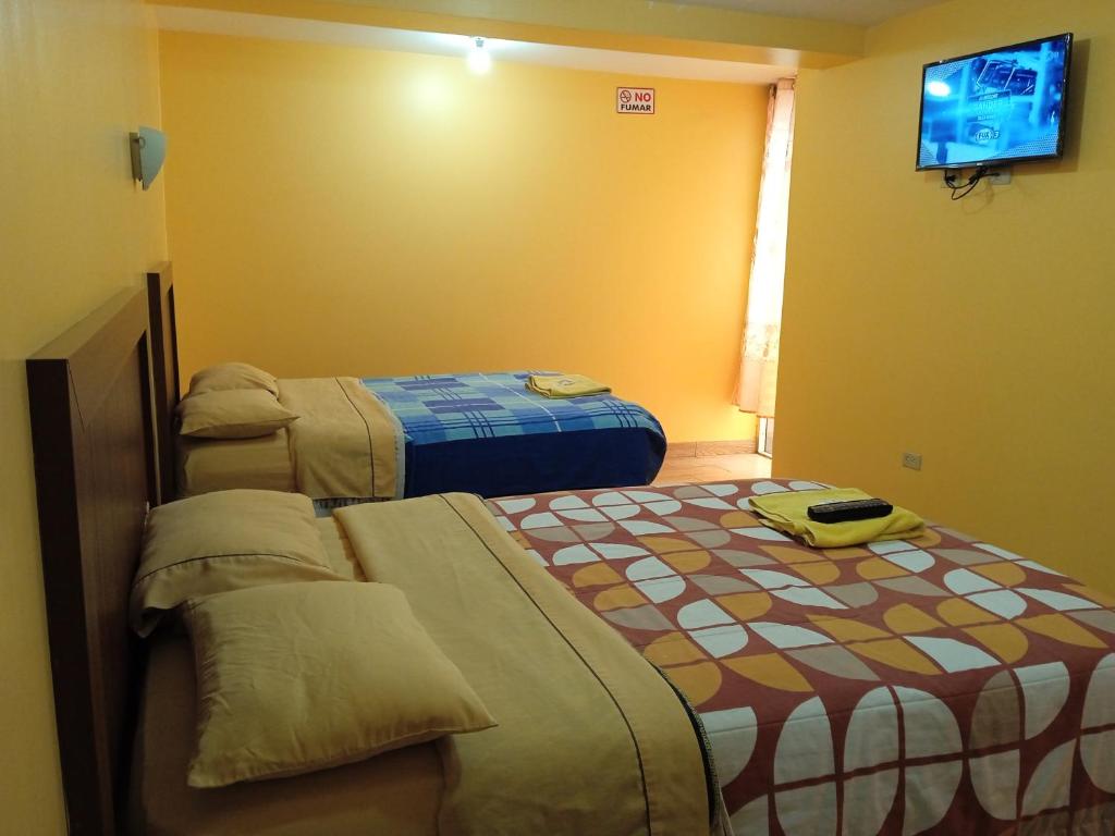 洛哈Hotel Residencial Miraflores的一间酒店客房,设有两张床和电视