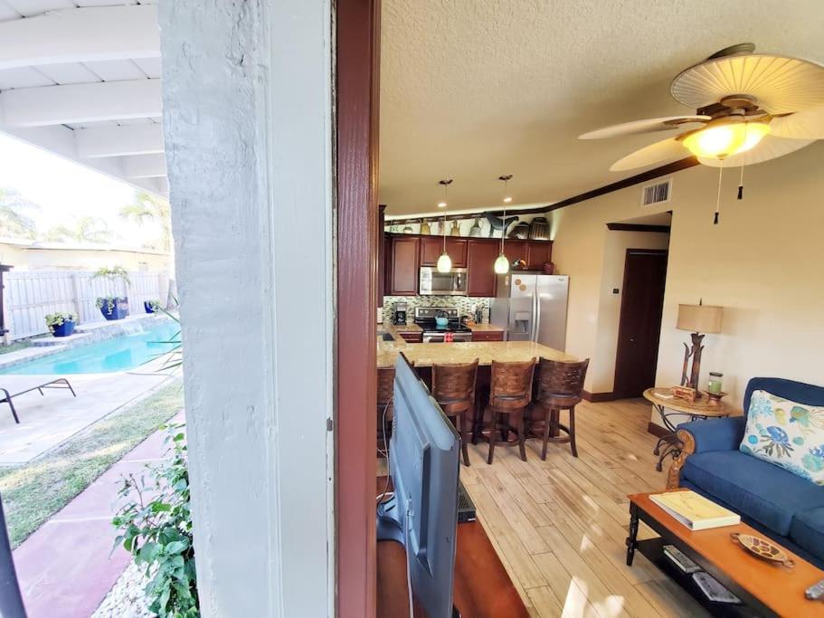 可可比奇Hawaiian Cottage - Heated Pool Walk to the Beach的一间带蓝色沙发的客厅和一间厨房