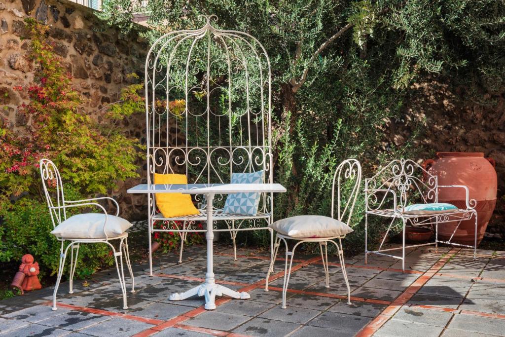 AtellaPalazzo Badiale history&rooms的花园里的一组椅子和一张桌子