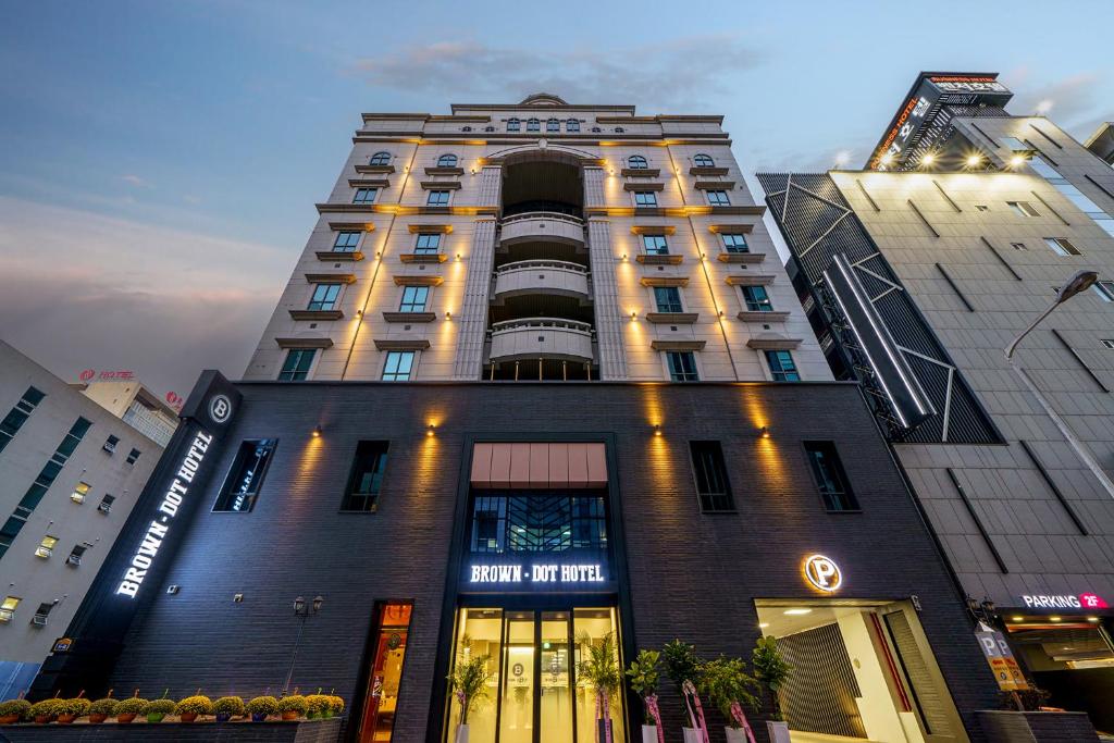 光州Browndot Hotel Sangmu的一座高大的建筑,上面有标志