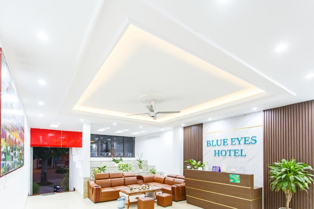 Văn LâmBlue Eyes Hotel的大堂,设有一张沙发和一张桌子