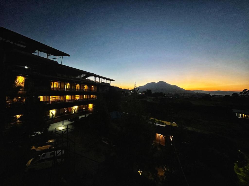 不拉士打宜卡朗乌鲁酒店的落日建筑,背景是山