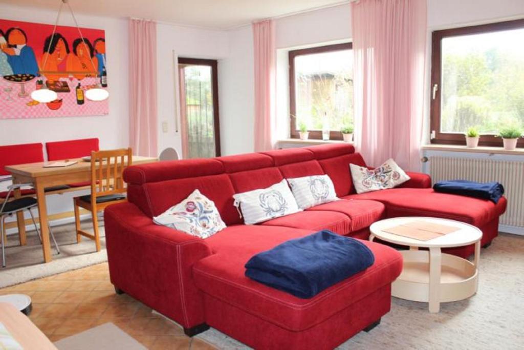 施奈塔赫Ferienwohnung Nikoll/Simon的客厅配有红色的沙发和桌子