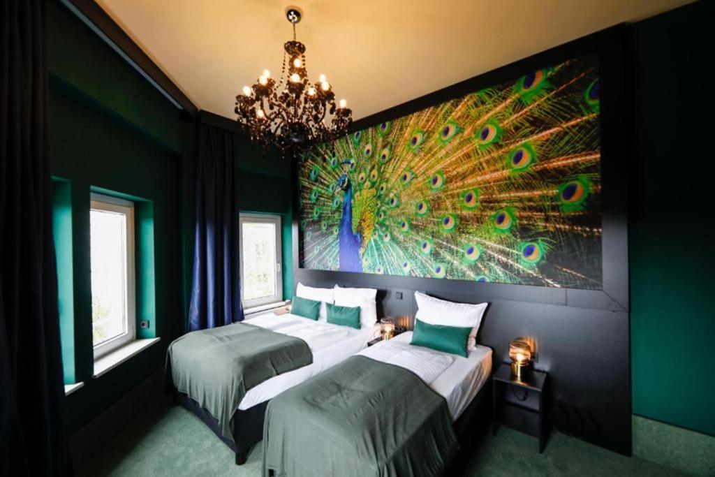 汉堡Sleephotels Casino的一间卧室设有两张床,墙上挂着孔雀画