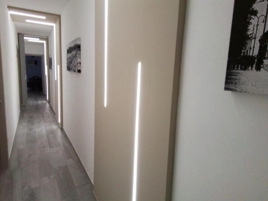 卡利亚里DELEDDA HOME的拥有白色墙壁的走廊和配有绘画的走廊