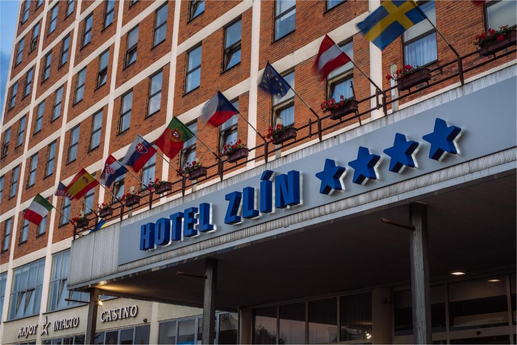 兹林Interhotel Zlín的一座有标志的建筑,上面有旗帜的酒店