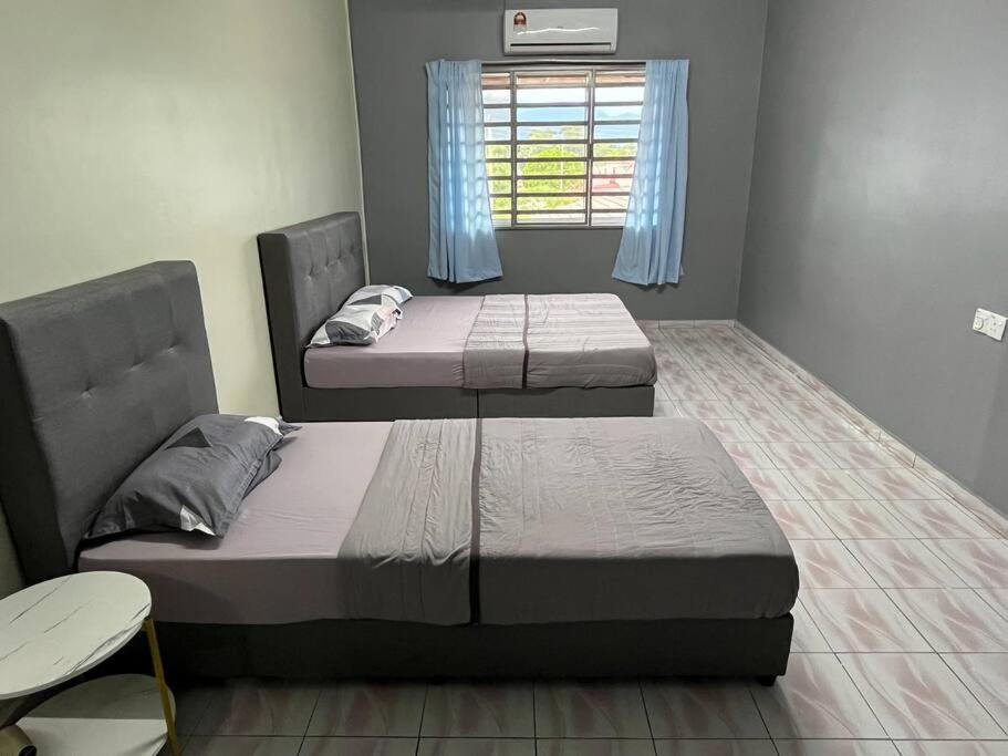 Malim NawarHomestay Malim Nawar的带窗户的客房内的两张床