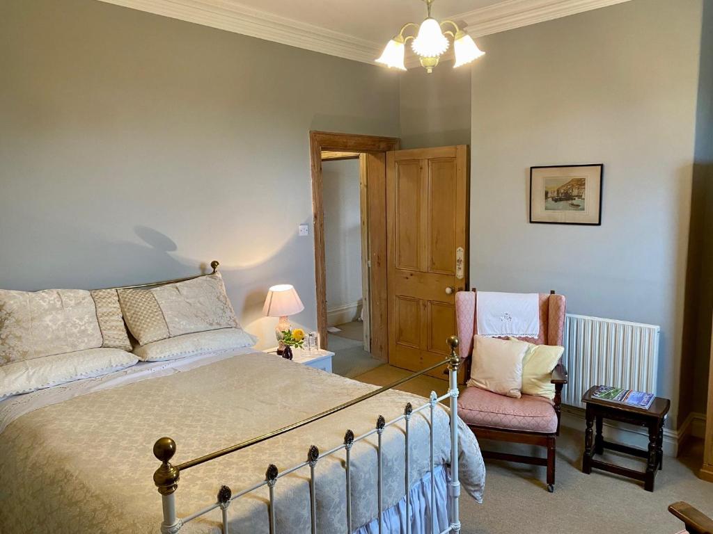 切斯特Golborne Manor Bed and Breakfast的一间卧室配有一张床和一把椅子