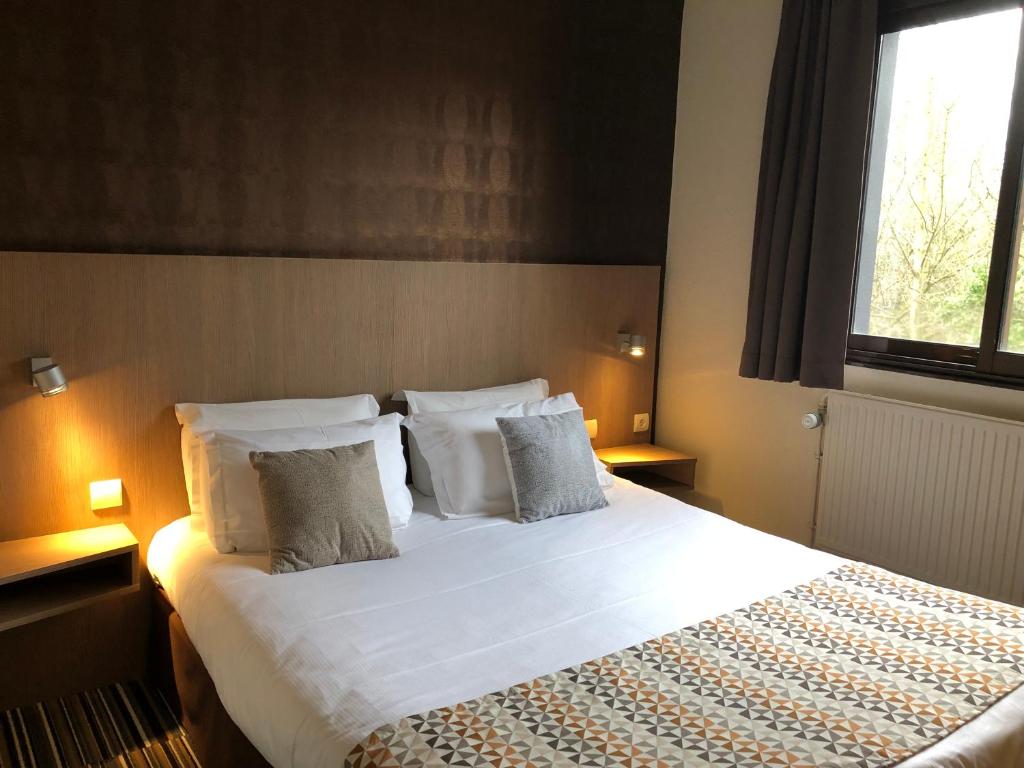 朗斯博拉尔特酒店的卧室配有一张带白色床单和枕头的大床。