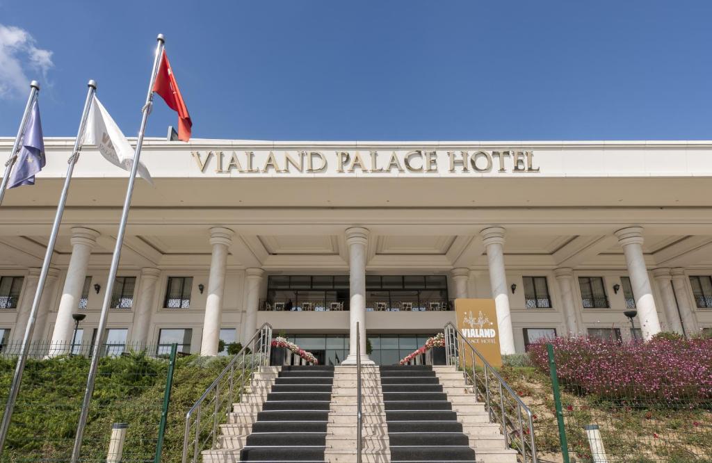 伊斯坦布尔Vialand Palace Hotel的一座拱形宫殿酒店,前面有旗帜