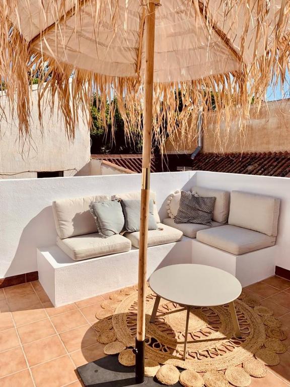马拉加Casita 10 Málaga, holiday home with roof terrace的带沙发、桌子和雨伞的客厅