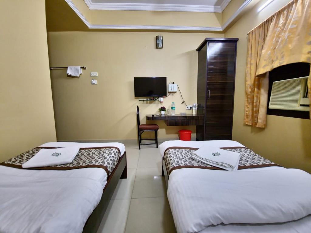 钦奈BHIMAS INN -Puratchi Thalaivar Dr M G Ramachandran Central Railway Station Chennai的酒店客房配有两张床和一张书桌