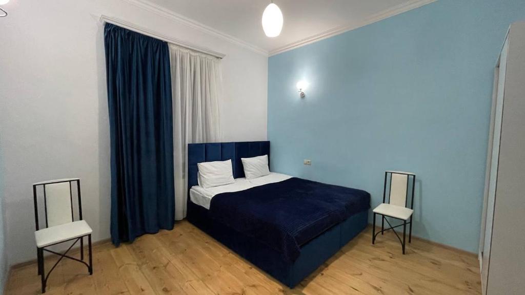 AshtarakAshtarak Garden GuestHouse的一间卧室配有蓝色的床和两把椅子