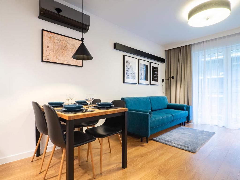 弗罗茨瓦夫City Comfort Wrocław的客厅设有餐桌和蓝色沙发