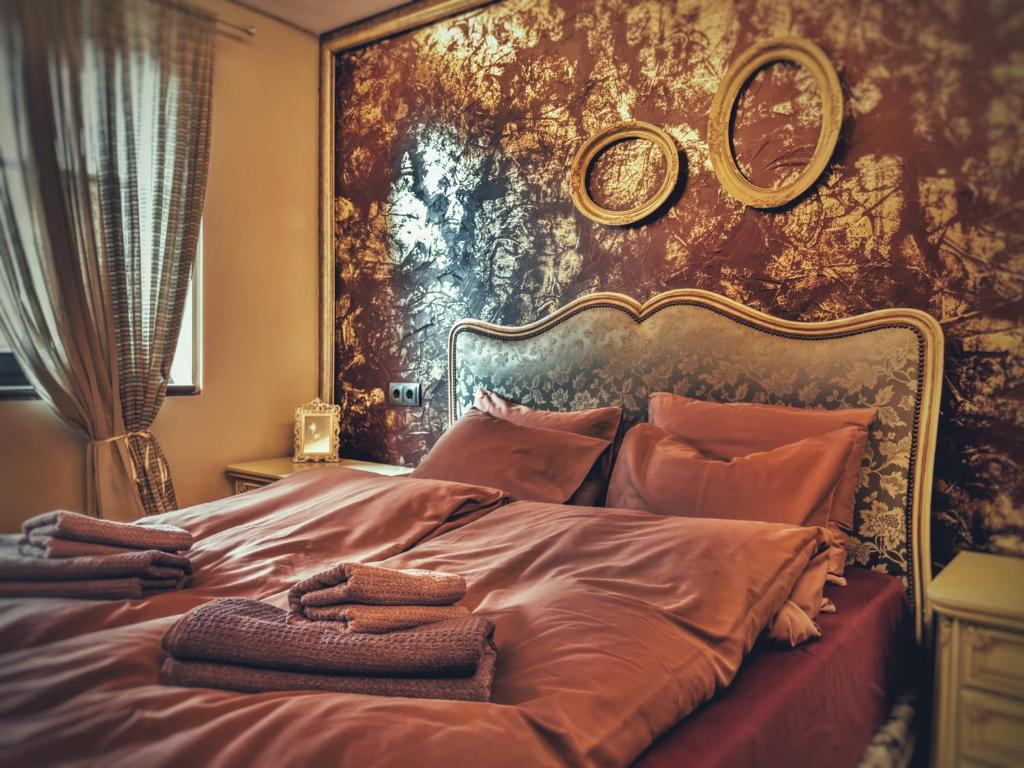 大特尔诺沃Тhe Bohemian Lodge-entire house with sauna的卧室配有一张大床,墙上挂有绘画作品