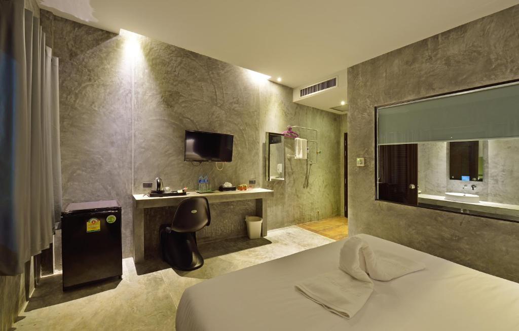 甲米镇绿洲度假村的酒店客房配有一张床、一张书桌和一台电视。