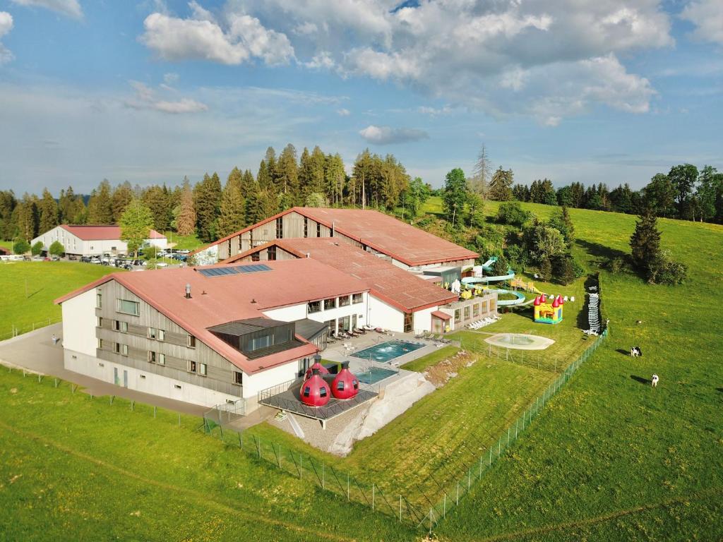 赛尼厄莱吉耶Jura Sport & Spa Resort的享有带游泳池的大房子的空中景致