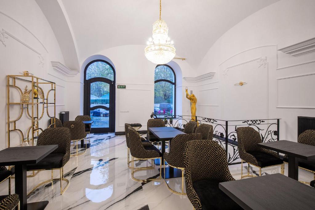 萨图马雷Hotel Vila Central Boutique Satu Mare的用餐室设有桌椅和窗户。