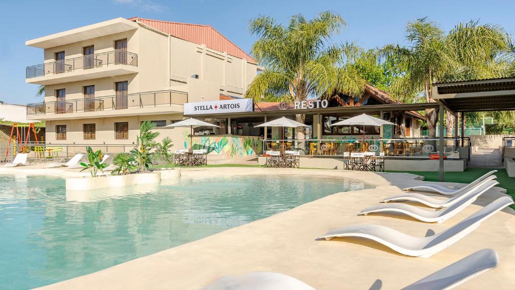 维拉卡洛斯帕兹Wooden Hotel的酒店前方的游泳池配有躺椅