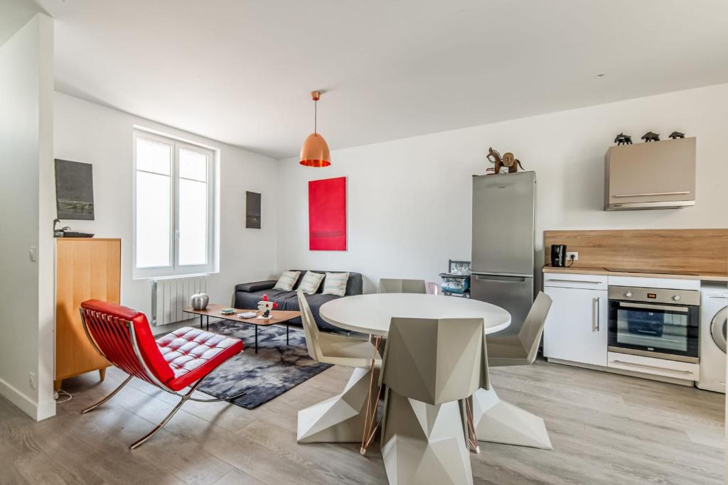 多维尔Design house in the center of Deauville - Welkeys的厨房以及带桌椅的起居室。