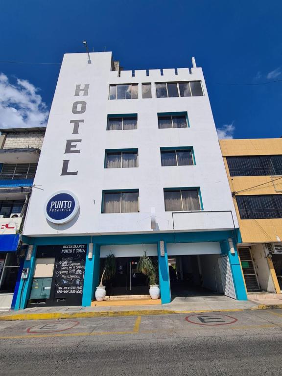 伊达尔戈州波萨里卡Hotel Punto Poza Rica的白色的建筑,上面有酒店标志