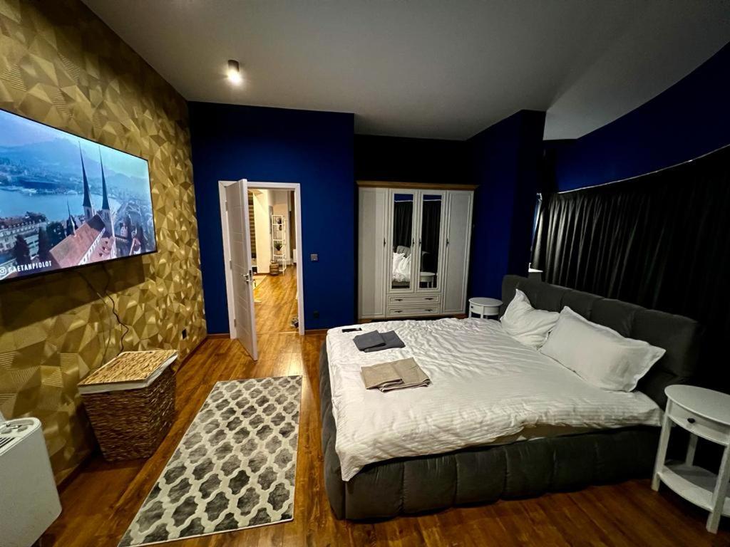 布拉戈耶夫格勒ROOF TOP LUXURY的一间卧室配有一张带蓝色墙壁的大床
