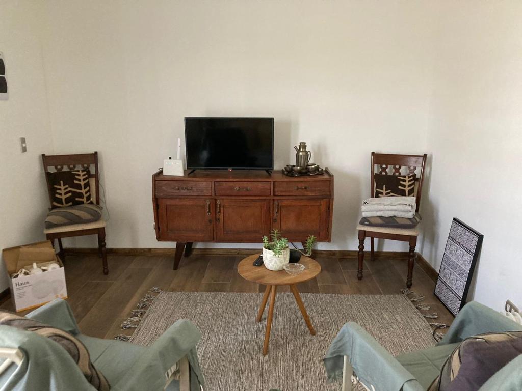 圣特雷莎德罗Container home的客厅配有电视和2把椅子