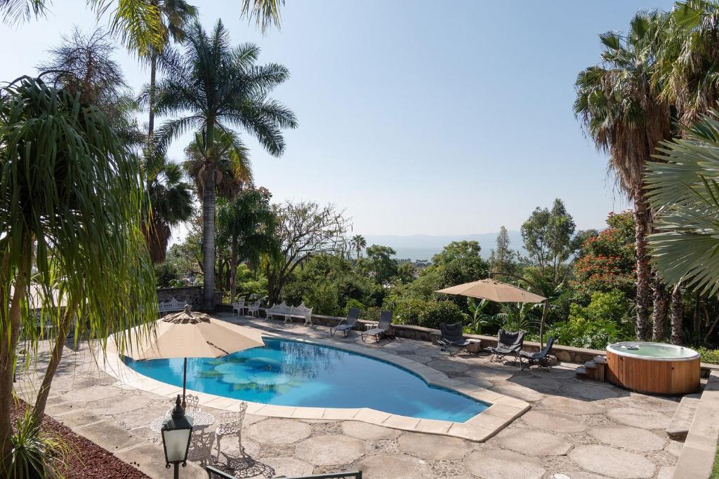 阿吉吉克Casa Galeana- Tropical 1-BD 1-WC Mountain Top Luxury Suite with Stunning Views的一个带椅子和遮阳伞的游泳池