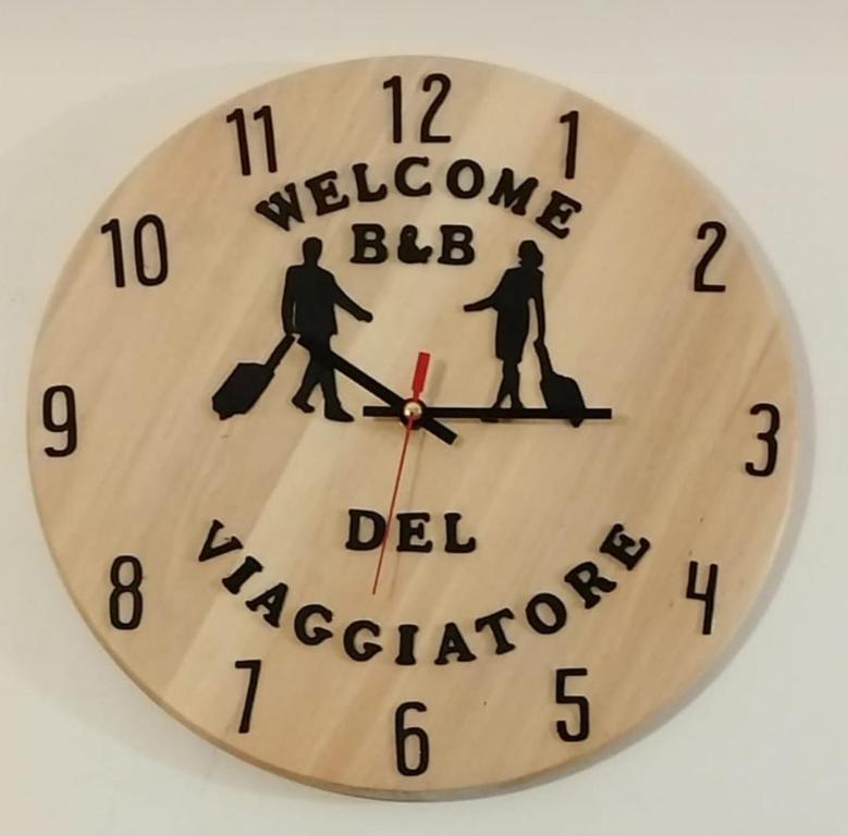 萨尔扎纳B&B Del viaggiatore的钟表,上面写着欢迎bdi邻居的字眼