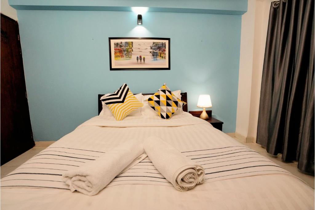 达卡Gulshan Lovely 3-Bedroom Luxury Apartment的一间卧室配有一张带蓝色墙壁的大床