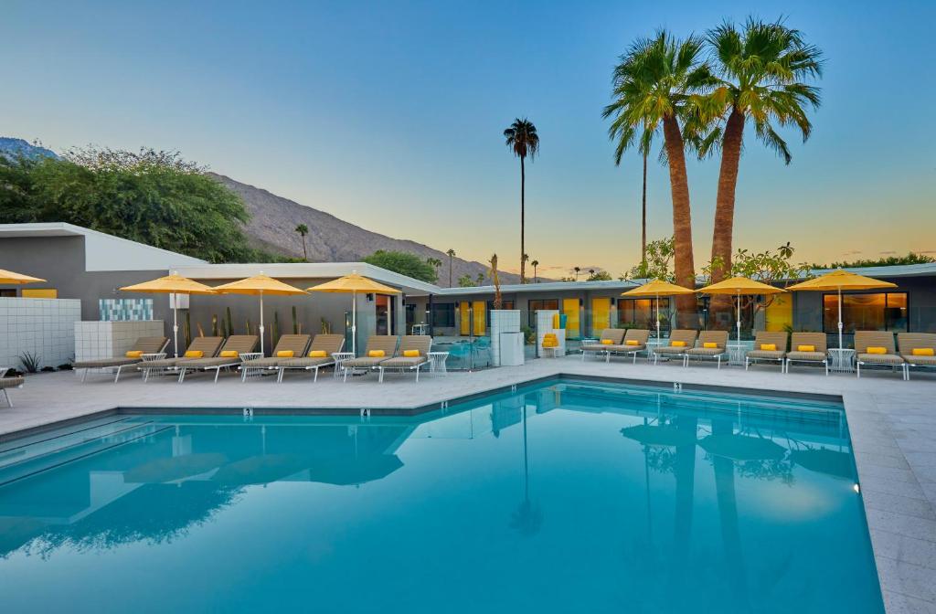 棕榈泉Twin Palms Resort - A Gay Men's Resort的一个带椅子和遮阳伞的游泳池