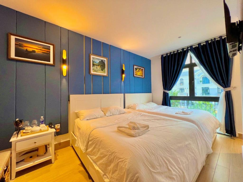 富国BISTRO HOTEL Grand World Phú Quốc的一间卧室配有一张带蓝色墙壁的大床