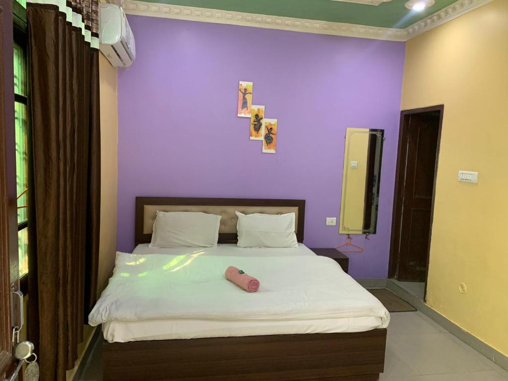 瑞诗凯诗MANIK GUEST HOUSE的一间卧室配有一张紫色墙壁的床
