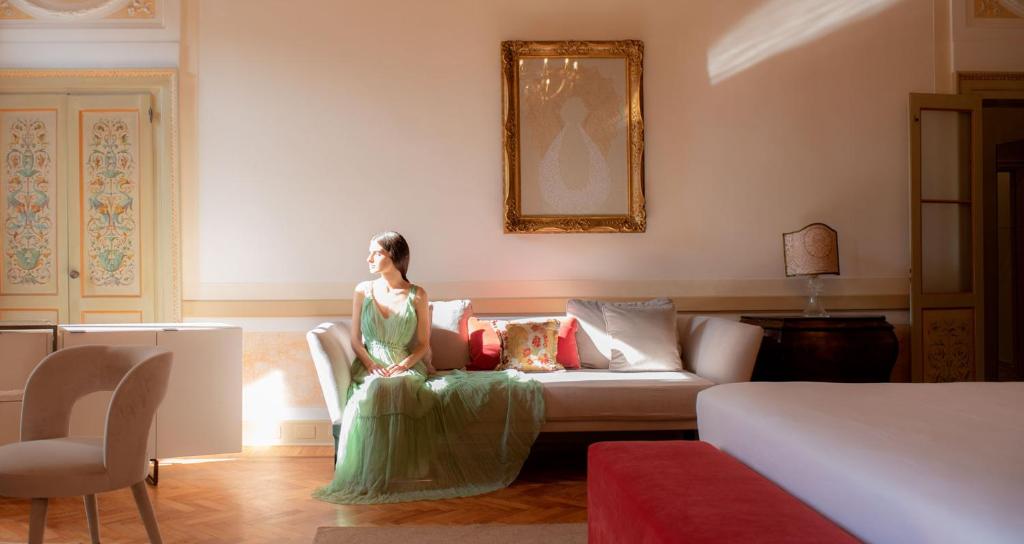 威尼斯Palazzo Maria Formosa的坐在客厅沙发上的女人
