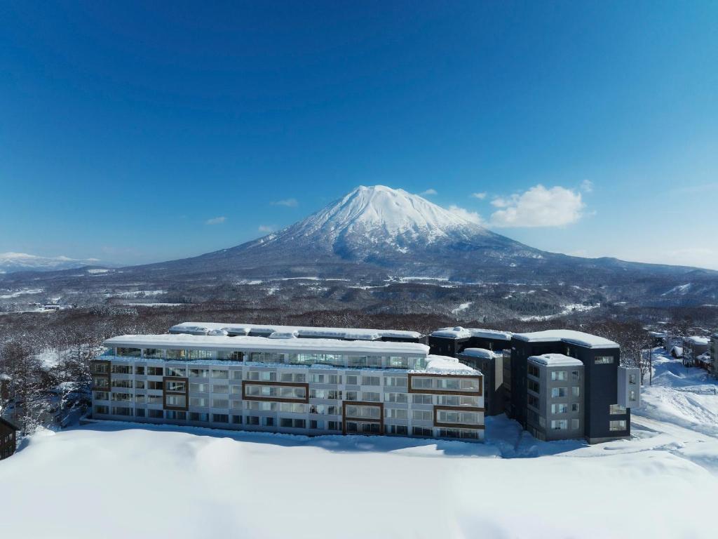 二世古Setsu Niseko的一座雪地中的建筑,背景是一座山