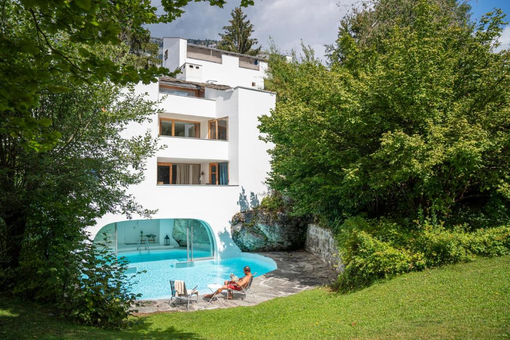 弗利姆斯卡萨拉斯卡格利亚斯酒店的一对夫妇坐在一座带游泳池的房子前