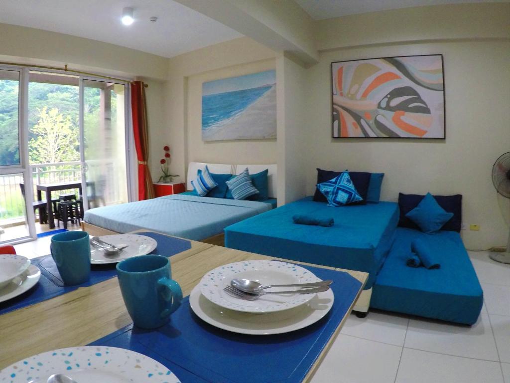 纳苏格布Beach Getaway at Pico de Loro Hamilo Coast Nasugbu Batangas的客厅配有两张床和一张带盘子的桌子