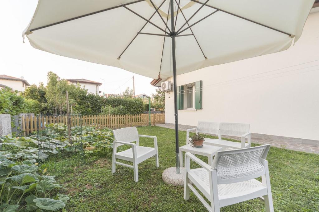 马尔泰拉戈Da Nonna Antonia的白色庭院桌子和遮阳伞下的椅子