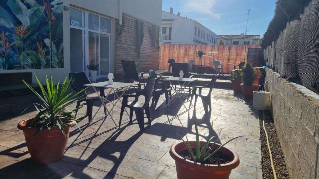 埃勒凡达尔Zona5 Apartamentos Turísticos的一个带桌椅和盆栽的庭院