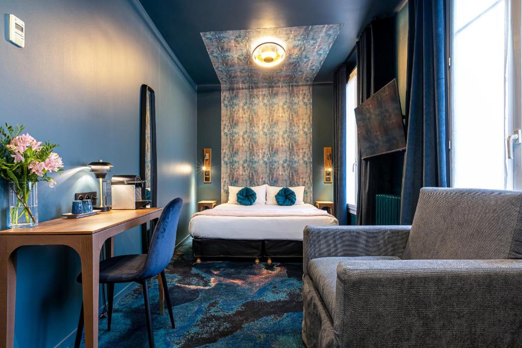 巴黎Hotel Glasgow Monceau by Patrick Hayat的一间卧室配有一张床、一张桌子和一张沙发
