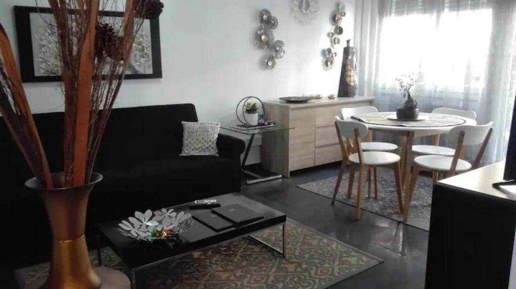 卡瓦拉City Center Comfortable Studio Apartment的客厅配有黑色沙发和桌子