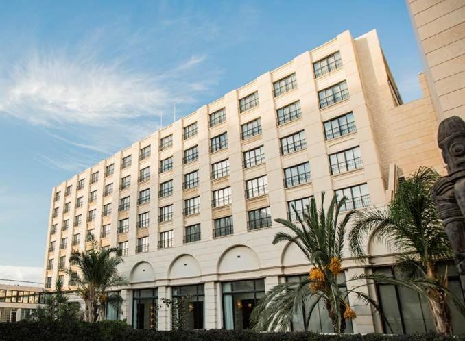 安曼大皇宫酒店的一座棕榈树环绕的大建筑