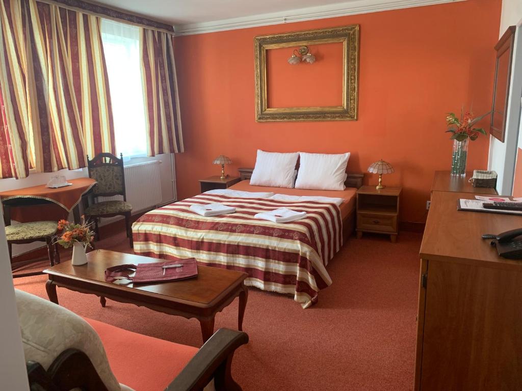 布拉格白屋酒店的酒店客房的床铺拥有橙色的墙壁