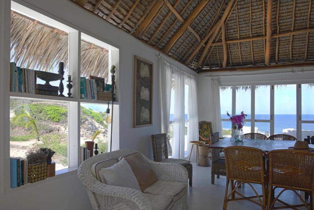 伊尼扬巴内Mar-Me-Quer, Eco Beach Retreat的客厅配有桌椅和窗户。