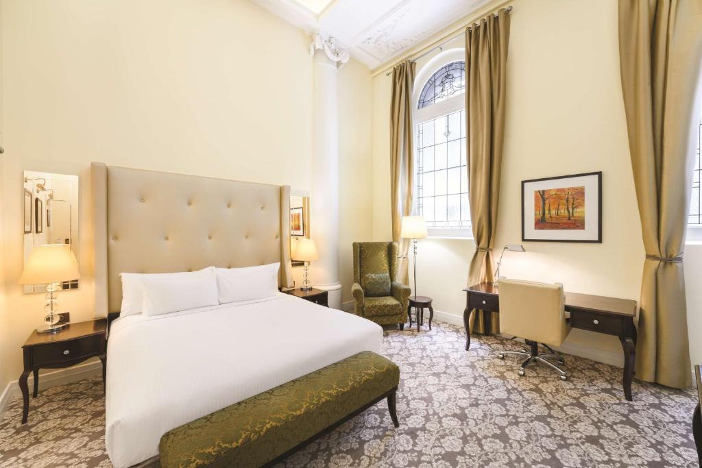 墨尔本墨尔本汇合酒店的酒店客房,配有一张床、一张桌子和椅子